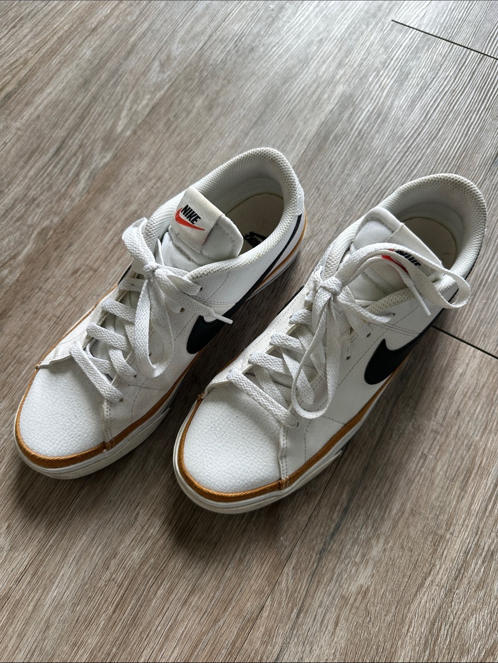 Nike Women’s White Sneakers with Black Swoosh and Gold Trim